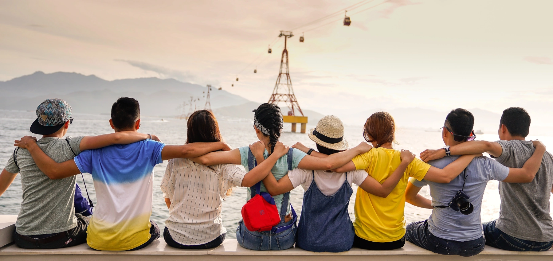 people holding shoulders sitting on wall
